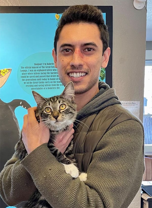 Jonathan holding a cat at an event